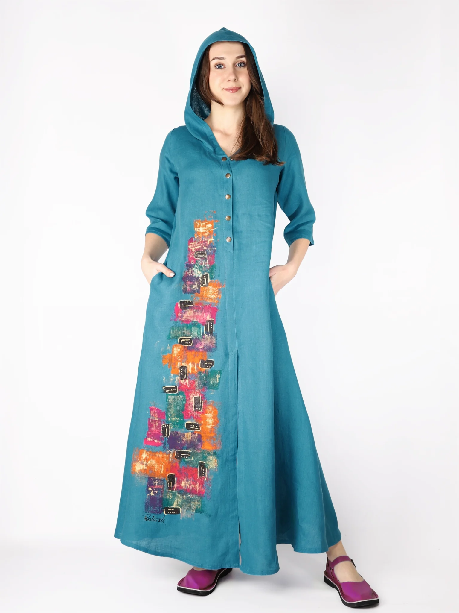 Niebieska sukienka maxi z lnu, rozpinana na dekolcie i wyposażona w kaptur, ręcznie malowana.