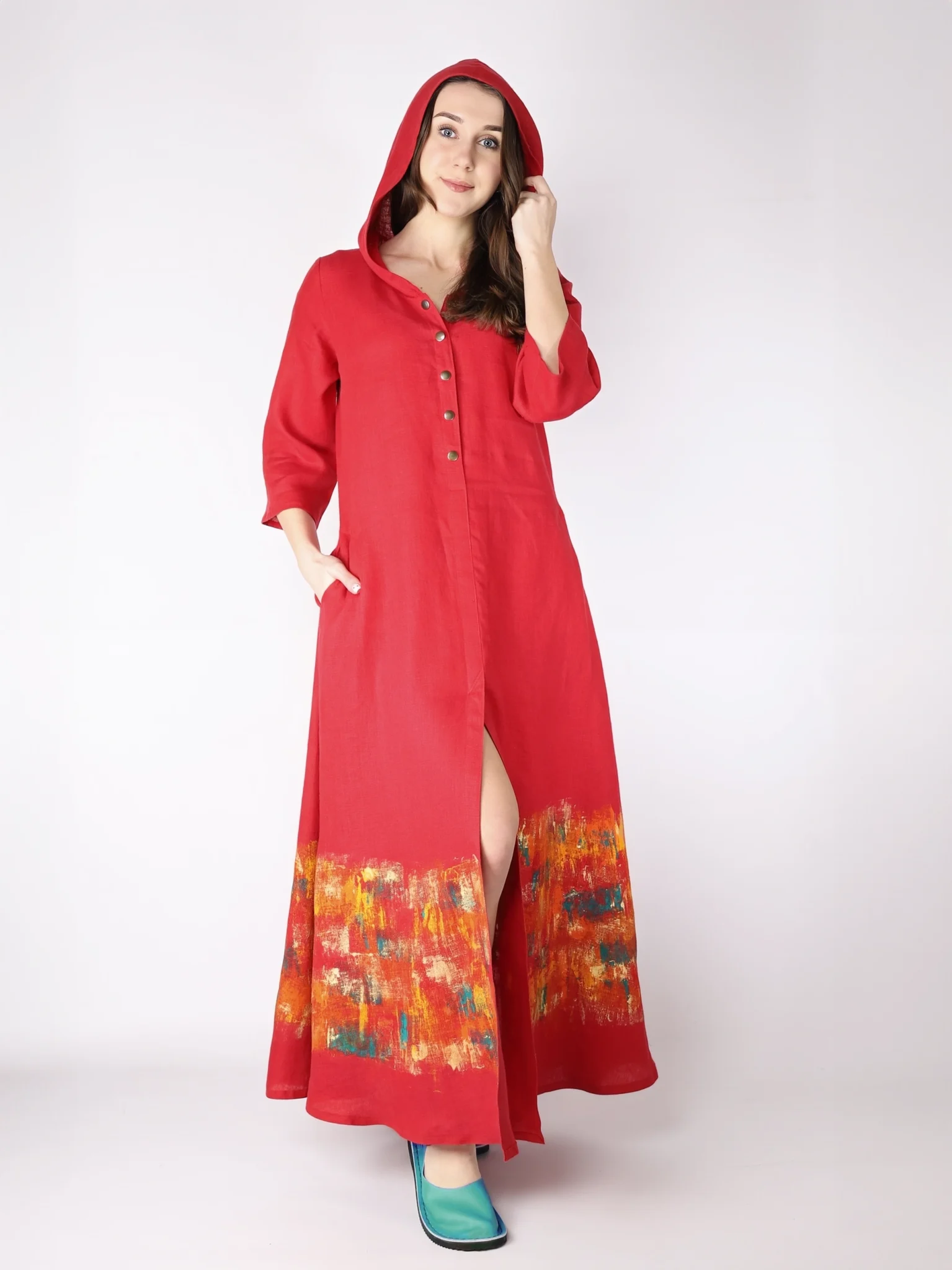Czerwona, lniana sukienka rozpinana z kapturem, o długości maxi i fasonie trapezowym, malowana ręcznie.